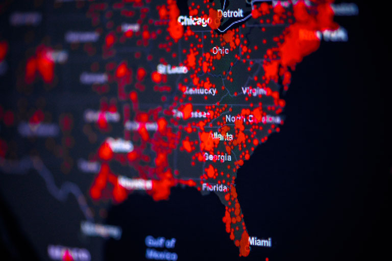 A heat-map of the United States showing more red in the locations where reported COVID cases are higher.
