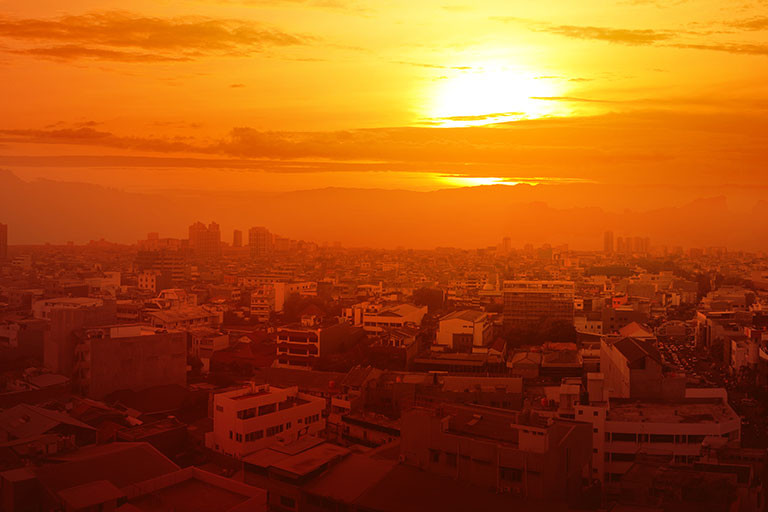 A hot and hazy sunset amidst a non-descript city.