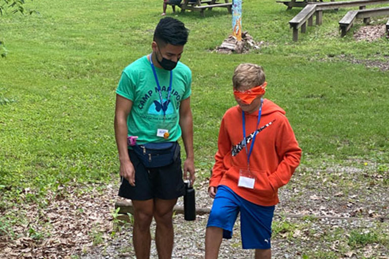 A counselor and kid playing a game at Camp Mariposa-Aaron's Place.